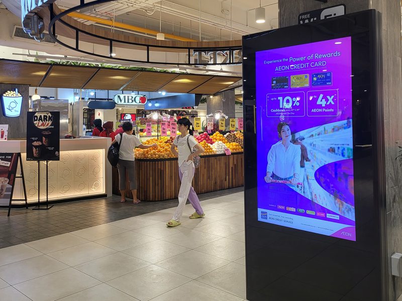 Kesion Malaysia digital standing screen displaying an AEON Credit Card promotion for 10% cashback in a mall.