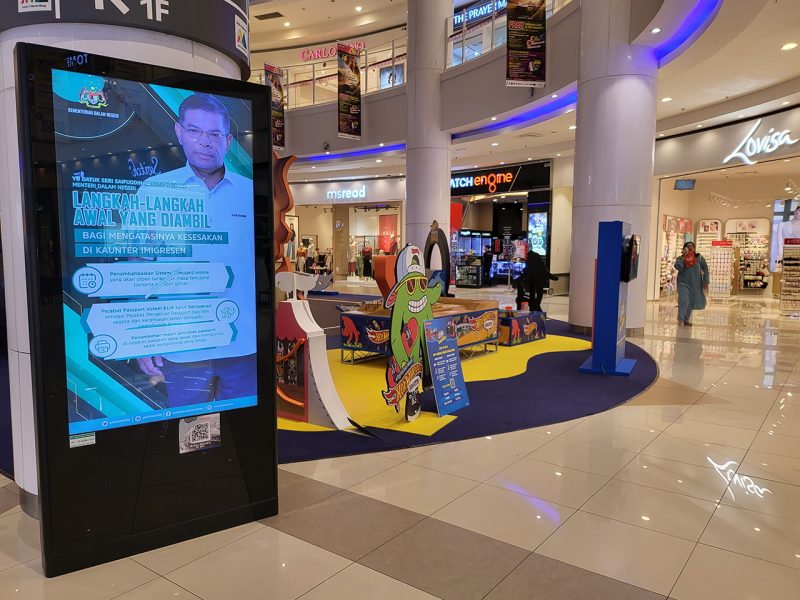 Kesion Malaysia digital standing screen displaying a Ministry of Home Affairs announcement regarding immigration counters.