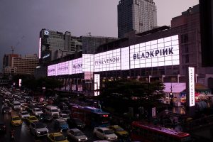 Massive PanOramix digital billboard on the Central World facade in Bangkok displaying a BLACKPINK Pink Venom campaign above heavy street traffic.
