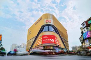 Massive corner digital billboard displaying a 50% off retail promotion on the Vincom Center Phạm Ngọc Thạch in Hanoi, Vietnam
