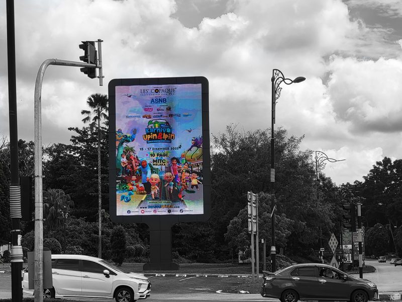 An outdoor digital screen at a traffic junction promoting Karnival Upin & Ipin, by Kesion Malaysia