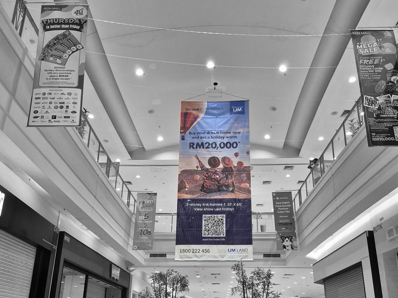 IJM Land Seremban 2 Sutera vertical banner hanging in AEON Mall atrium alongside other mall promotional banners