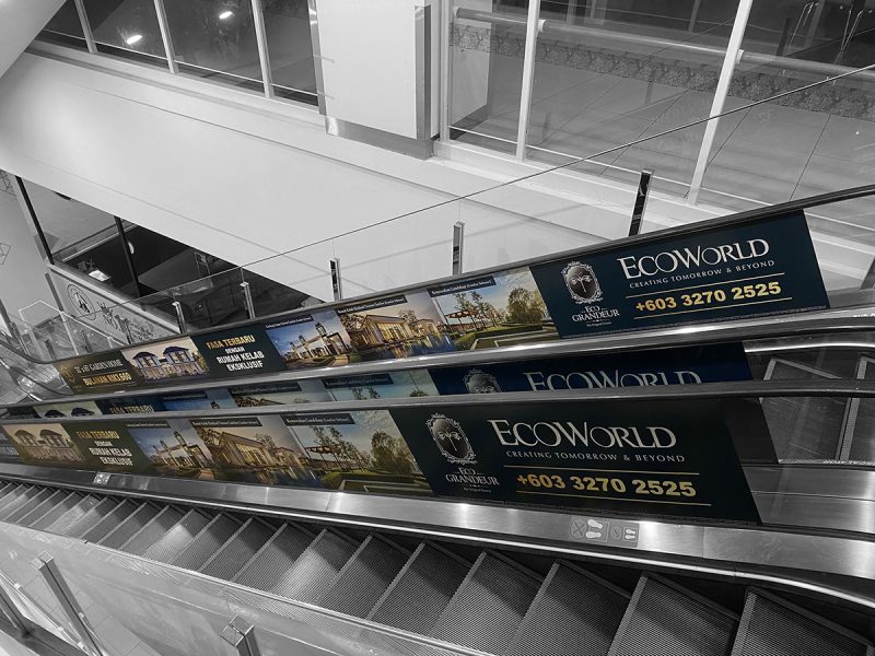 EcoWorld Eco Grandeur advertising panels along a shopping mall escalator, showing property renders and the contact number +603 3270 2525